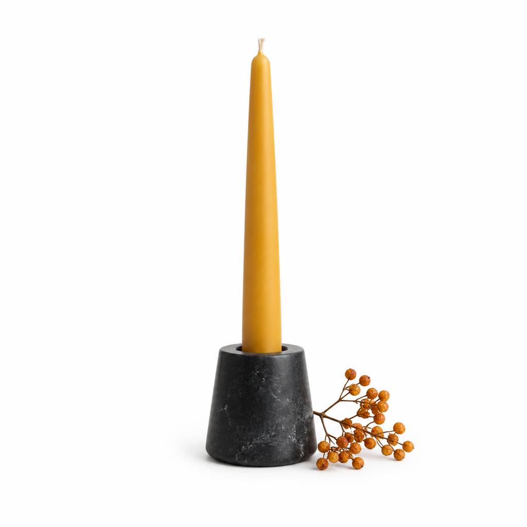 Vela de cera de abeja en un portavelas de piedra negra
